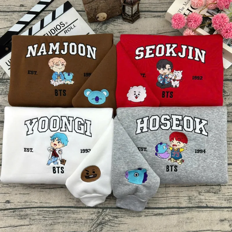 Pulls couple brodés BTS en version chibi : Namjoon, Seokjin, Yoongi et Hoseok sur sweatshirts assortis, personnages BT21 brodés sur les manches