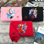 Pulls couple brodés Spider-Verse style pop art : Gwen Stacy sur sweatshirt rose clair, Miles Morales sur noir et Spider-Man sur rouge, araignée brodée sur les manches