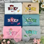 Pulls couple brodés Toy Story : Jessie, Woody, Lotso, Buzz l’Éclair, Bo Peep et Lilypad sur sweatshirts assortis, mains formant un cœur brodées sur les manches